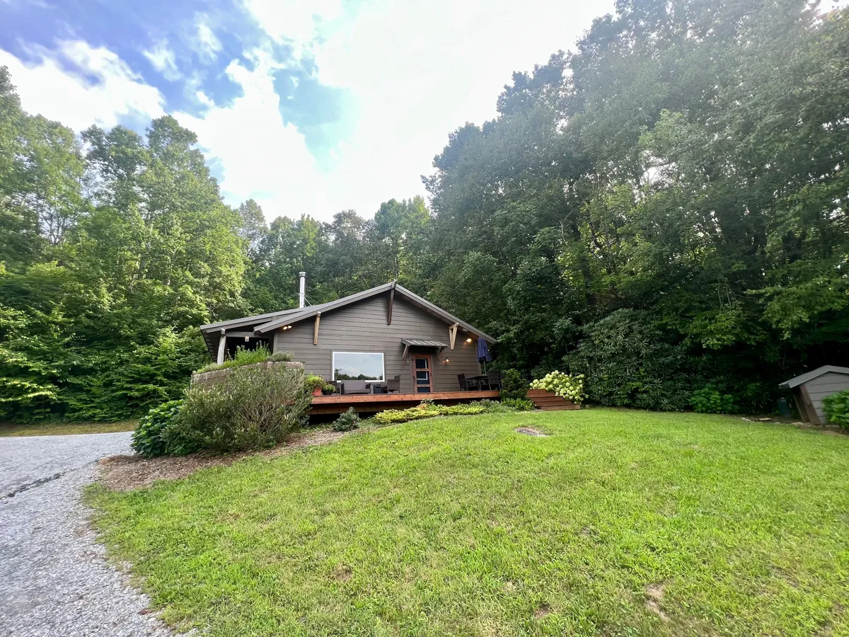 An exterior view of the house with a spacious deck, set against a backdrop of abundant greenery. The scene shows ample outdoor space, ideal for family games, picnics, and enjoying fresh air, evoking the fun and freedom described in the section.